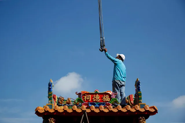 An employee moves a ready-made Chinese traditional temple during delivery in Taichung, Taiwan July 6, 2016. (Photo by Tyrone Siu/Reuters)