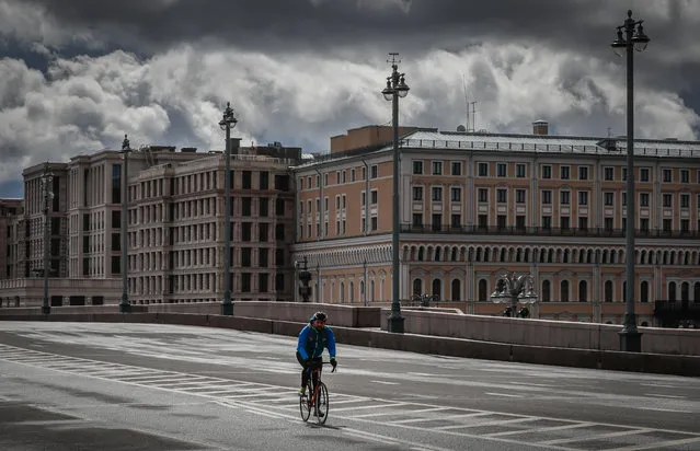 A man rides a bike on deserted street in center Moscow, Russia, 17 April 2020. Russian President Vladimir Putin extended the current nationwide lockdown with stay-at-home orders until the end of April in a bid to slow down the spread of the pandemic COVID-19 disease caused by the SARS-CoV-2 coronavirus. (Photo by Yuri Kochetkov/EPA/EFE)