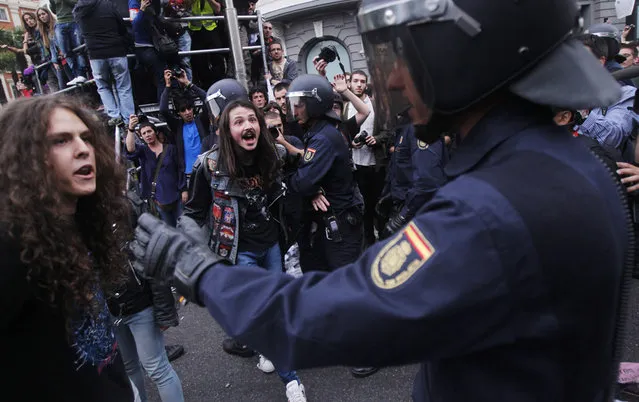 Police clash with the protestors during the march to the parliament against austerity measures announced by the Spanish government in Madrid, Spain, Tuesday, Sept. 25, 2012.  The demonstration, organized behind the slogan 'Occupy Congress,' was expected to draw thousands of people.  Madrid authorities said some 1,300 police would be deployed. The protestors call for Parliament to be dissolved and fresh elections held, claiming the government's austerity measures show the ruling Popular Party misled voters to get elected last November. (AP Photo/Andres Kudacki)