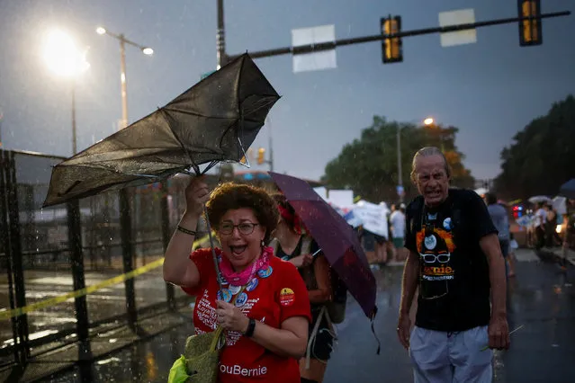 Supporters of U.S. Senator Bernie Sanders react to heavy rain fall as they gather to protest outside the site of the 2016 Democratic National Convention in Philadelphia, Pennsylvania on July 25, 2016. (Photo by Adrees Latif/Reuters)