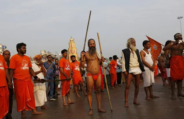 A sadhu or Hindu holy man holds a sword as he and others wait to take a dip in the waters of Godavari river during the second “Shahi Snan” (grand bath) at Kumbh Mela or Pitcher Festival in Nashik, India, September 13, 2015. (Photo by Adnan Abidi/Reuters)