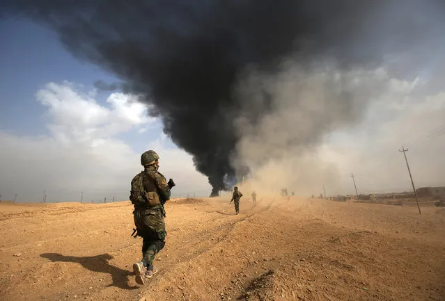 Iraqi forces and members of the Hashed al-Shaabi (Popular Mobilisation units) advance towards the city of al-Qaim, in Iraq's western Anbar province near the Syrian border as they fight against remnant pockets of Islamic State group jihadists on November 3, 2017. (Photo by Ahmad Al-Rubaye/AFP Photo)