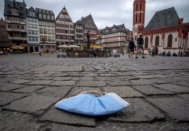A face mask was left behind on the Roemerberg square in Frankfurt, Germany, Sunday, June 14, 2020. Due to the coronavirus masks must be worn in shops and public transport. (Photo by Michael Probst/AP Photo)