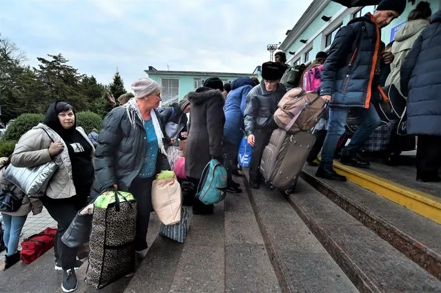 Evacuees from Kherson gather upon their arrival at the railway station in Dzhankoi, Crimea, Friday, October 21, 2022. Russian authorities have encouraged residents of Kherson to evacuate, warning that the city may come under massive Ukrainian shelling. (Photo by AP Photo/Stringer)