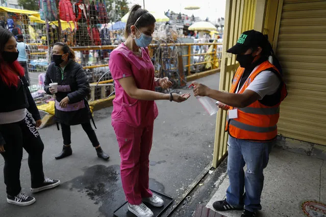A shopper is given antibacterial gel as she enters Mercado Sonora, which reopened ten days ago with measures to reduce congestion and limit the spread of the coronavirus, in Mexico City, Thursday, June 25, 2020. (Photo by Rebecca Blackwell/AP Photo)