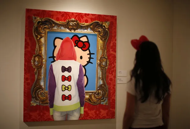 A woman views the painting “Alegory of Love” by Marc Dennis at the “Hello! Exploring the Supercute World of Hello Kitty” museum exhibit in honor of Hello Kitty's 40th anniversary, at the Japanese American National Museum in Los Angeles, California October 10, 2014. (Photo by Lucy Nicholson/Reuters)
