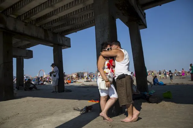 A man and woman kiss under the boardwalk at Coney Island Beach in Brooklyn, New York August 15, 2015. (Photo by Andrew Kelly/Reuters)