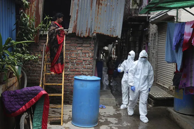 Health workers walk to screen people for COVID-19 symptoms at a slum, in Mumbai, India, Friday, July 10, 2020. India has overtaken Russia to become the third worst-affected nation by the coronavirus pandemic. (Photo by Rafiq Maqbool/AP Photo)