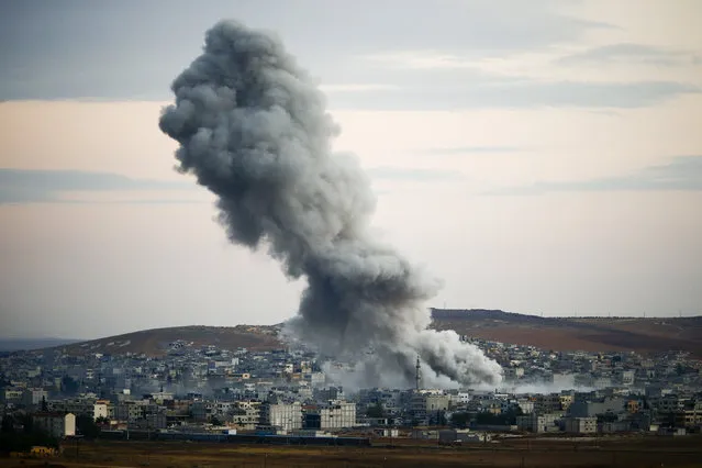 Smoke rises over Syrian town of Kobani after an airstrike, as seen from the Mursitpinar border crossing on the Turkish-Syrian border in the southeastern town of Suruc in Sanliurfa province, October 18, 2014. (Photo by Kai Pfaffenbach/Reuters)