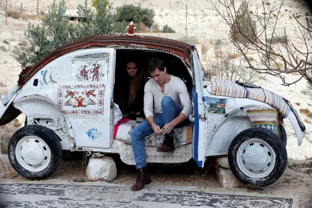 U.S. tourists Stafford Newsome and Kaitlin Taft, sit in a Volkswagen Beetle, the “world's smallest hotel”, as his owner Mohammed Al-Malahim claims, in Shoubak, Jordan on December 21, 2017. (Photo by Muhammad Hamed/Reuters)