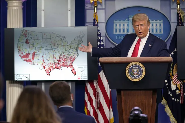 President Donald Trump gestures towards a graphic on the coronavirus outbreak as he speaks during a news conference at the White House, Thursday, July 23, 2020, in Washington. (Photo by Evan Vucci/AP Photo)