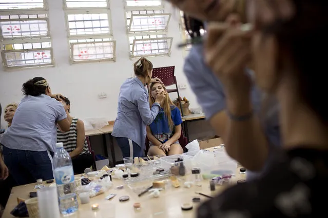 In this Monday, October 27, 2014 photo, prisoners apply makeup on models before a show in Neve Tirza prison in Ramle, central Israel. (Photo by Oded Balilty/AP Photo)
