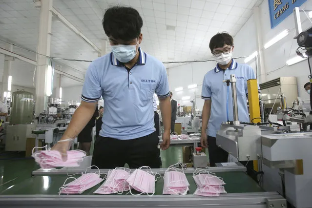 Workers arrange face masks to protect against the coronavirus at a mask factory where U.S. Health and Human Services Secretary Alex Azar visited during an inspection tour in New Taipei City, Taiwan, Wednesday, August 12, 2020. (Photo by Chiang Ying-ying/AP Photo)
