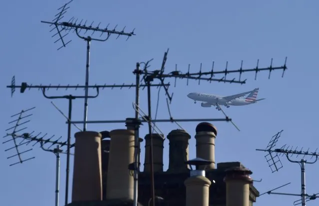 A passenger aircraft is seen through television aerials on roofs as it makes its landing approach to Heathrow airport in west London, Britain April 27, 2016. (Photo by Toby Melville/Reuters)