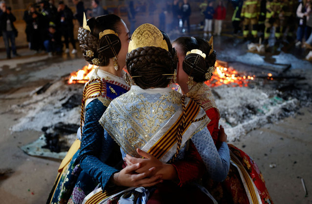 Girls embrace each other as giant sculptures are burned on the last day of Spain's Fallas Festival in Valencia, Spain, on March 19, 2024. (Photo by Eva Manez/Reuters)