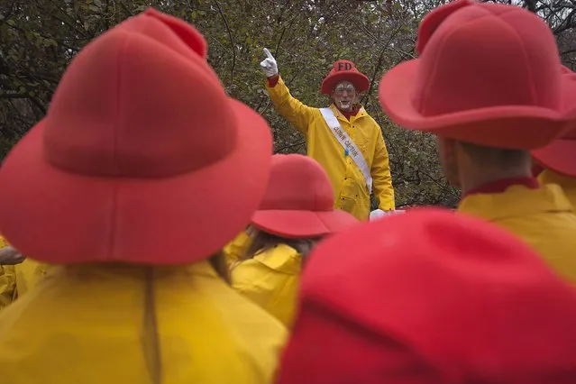 A clown captain gives last minute instructions to his fellow clowns as they prepare to participate in the Macy's Thanksgiving Day Parade in New York, November 27, 2014. (Photo by Carlo Allegri/Reuters)