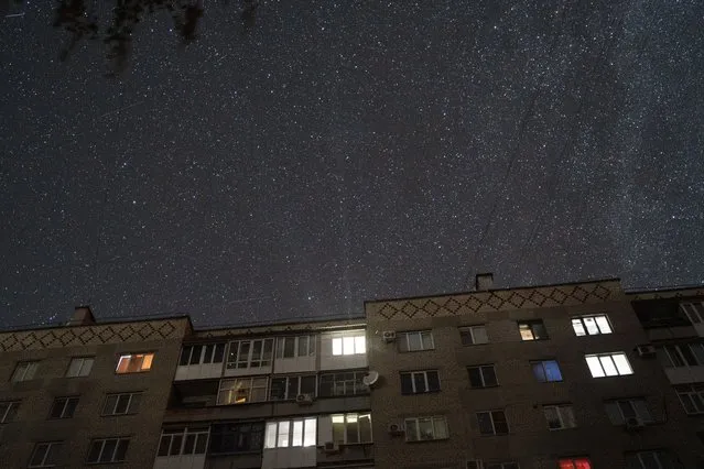 Stars fill the sky over a residential building before the curfew in Pokrovsk, Donetsk region, eastern Ukraine, Friday, August 26, 2022. (Photo by Leo Correa/AP Photo)