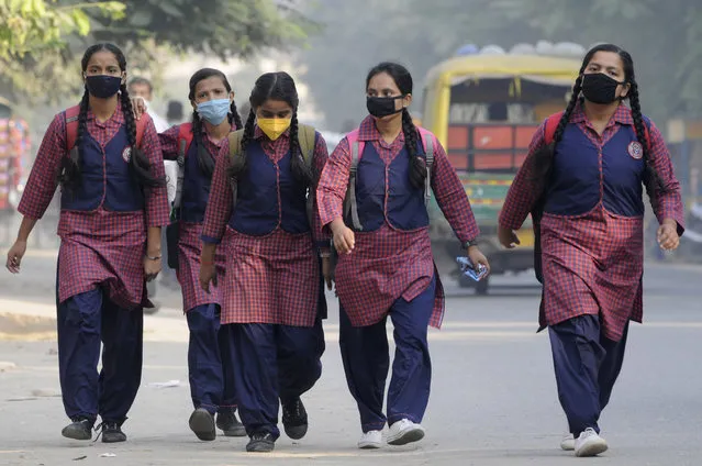 Students wearing face masks head towards Rajkiya Balika Inter College following a partial reopening since the nationwide lockdown was imposed to curb the spread of coronavirus disease at Sector 51, on October 19, 2020 in Noida, India. (Photo by Sunil Ghosh/Hindustan Times via Getty Images)