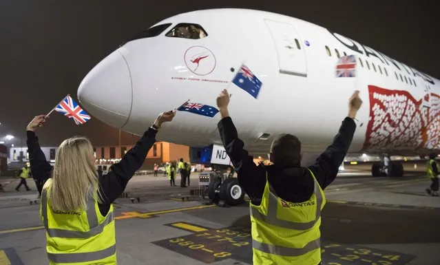 Qantas staff wave Australian and British flags at the Boeing 787 Dreamliner after landing at Heathrow Airport on March 25, 2018 in London, United Kingdom. The historic flight into London from Australia flew the 14,498km non-stop in 17 hours and 6 minutes. This is the first direct flight service from Australia to London launching this weekend. (Photo by James D. Morgan/Getty Images)