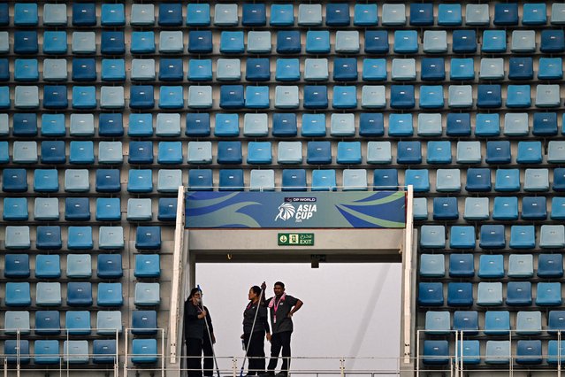 Janitors stand amid empty seats at the Dubai International Stadium in Dubai on September 17, 2025, ahead of the Asia Cup 2025 Twenty20 international cricket match between United Arab Emirates and Pakistan. Pakistan's Asia Cup match with the United Arab Emirates was delayed by at least one hour on September 17, as the fallout rumbles on from a handshake row with arch-rivals India. (Photo by Sajjad Hussain/AFP Photo)