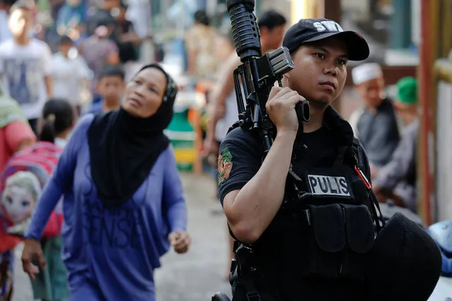 A policeman holds his weapon during a drug raid in Quezon City, Metro Manila, Philippines, October 12, 2016. (Photo by Damir Sagolj/Reuters)