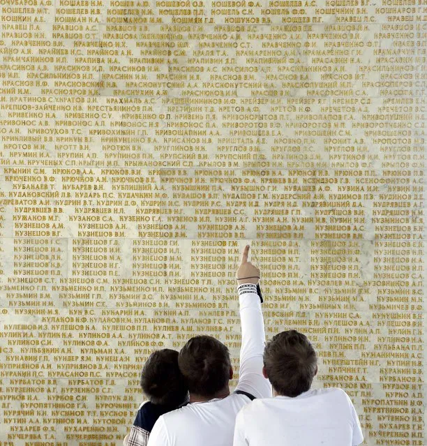 Ukrainians looks for their family surname engraved on the memorial to Soviet Union Heroes in Kiev. (Photo by Efrem Lukatsky/Associated Press)