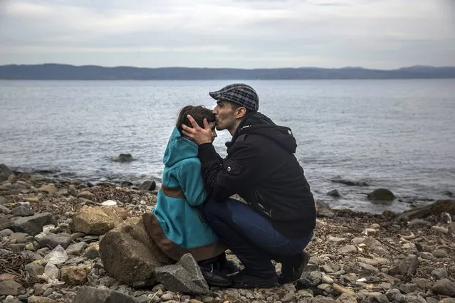 A Syrian man kisses his daughter shortly after disembarking from a dinghy at a beach on the Greek island of Lesbos after crossing the Aegean sea from the Turkish coast, Monday, November 16, 2015. Greek authorities say 1,244 refugees and economic migrants have been rescued from frail craft in danger over the past three days in the Aegean Sea, as thousands continue to arrive on the Greek islands. (Photo by Santi Palacios/AP Photo)