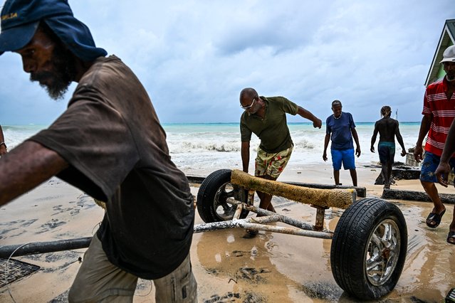 Residents clear the boat from the street as it gets flooded after Hurricane Beryl passes in the parish of Saint James, Barbados, near Bridgetown, Barbados on July 1, 2024. Hurricane Beryl plowed toward the southeast Caribbean early Monday as officials warned residents to seek shelter ahead of powerful winds and swells expected from the Category 3 storm. (Photo by Chandan Khanna/AFP Photo)