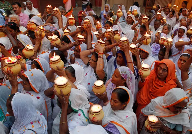 Widows, who have been abandoned by their families, carry earthen lamps as they gather inside a temple to celebrate Diwali, organised by non-governmental organisation Sulabh International in Vrindavan, India, October 27, 2016. (Photo by Jitendra Prakash/Reuters)