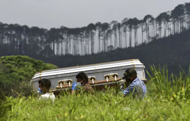 Relatives carry the coffin of an alleged victim of the new coronavirus at the Parque Memorial Jardin de los Angeles cemetery, 14 km north of Tegucigalpa, on June 21, 2020. Honduras is overwhelmed by deaths caused by COVID-19 and the large number of people infected that are admitted every day in different hospitals across the country. (Photo by Orlando Sierra/AFP Photo)