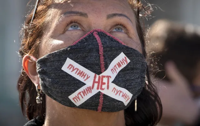 A woman wears a face mask to protect against coronavirus infection with a sign “No to Putin” during a protest against constitutional amendments at the Palace Square in St.Petersburg, Russia, Wednesday, July 1, 2020. The vote on the constitutional amendments that would reset the clock on Russian President Vladimir Putin's tenure and enable him to serve two more six-year terms is set to wrap up Wednesday. (Photo by Dmitri Lovetsky/AP Photo)