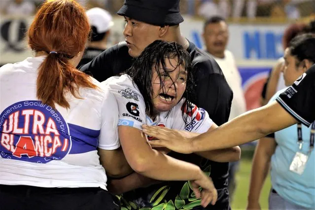 A woman is held by other as she cries following a stampede during a football match between Alianza and FAS at Cuscatlan stadium in San Salvador, on May 20, 2023. Nine people were killed May 20, 2023 in a stampede at an El Salvador stadium where soccer fans had gathered to watch a local tournament, police said. (Photo by Milton Flores/AFP Photo)