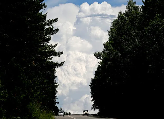 Cars drive along the “Yenisei” M54 federal highway, with heavy clouds seen in the sky, through the Siberian Taiga area outside Krasnoyarsk, Russia, July 5, 2016. (Photo by Ilya Naymushin/Reuters)