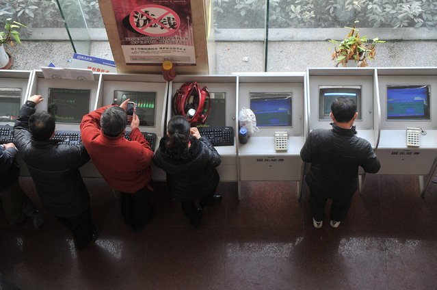 Investors look at a computer screen showing stock information at a brokerage house in Hefei, Anhui province, January 19, 2015. (Photo by Reuters/Stringer)