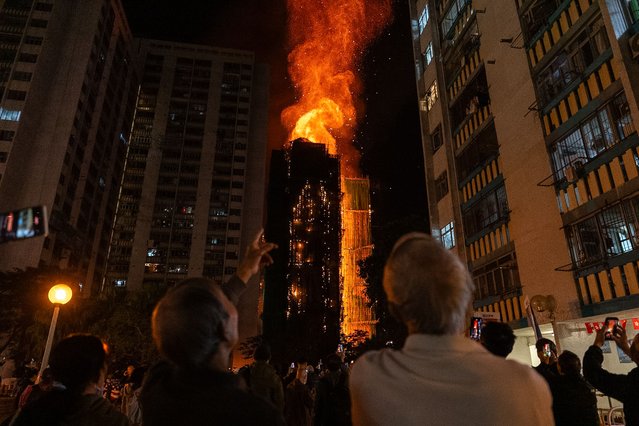 People look at flames engulfing a building after a fire broke out at Wang Fuk Court, a residential estate in the Tai Po district of Hong Kong's New Territories, Wednesday, November 26 2025. (Photo by Chan Long Hei/AP Photo)
