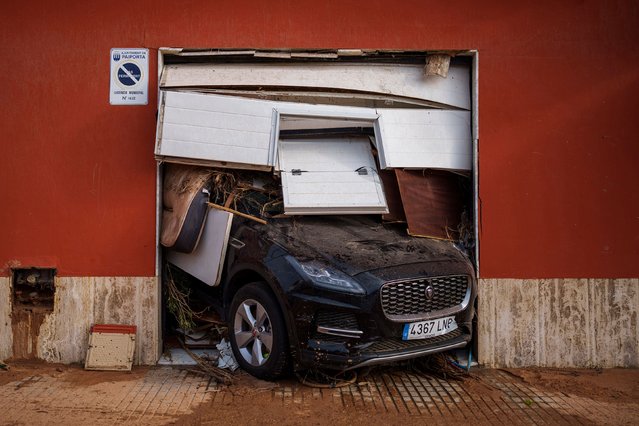 A car sticks out of a garage in Valencia, Spain, on Saturday, November 2, 2024. Flash flooding devastated the Valencia region, which saw its heaviest rainfall in 28 years. (Photo by Manu Fernandez/AP Photo)