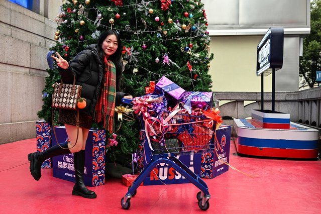 A woman poses for pictures next to a Christmas tree in a shop selling Russian products in Wuhan, in China's central Hubei province on December 22, 2024, ahead of the fifth anniversary of China confirming its first death from the Covid-19 coronavirus. (Photo by Hector Retamal/AFP Photo)