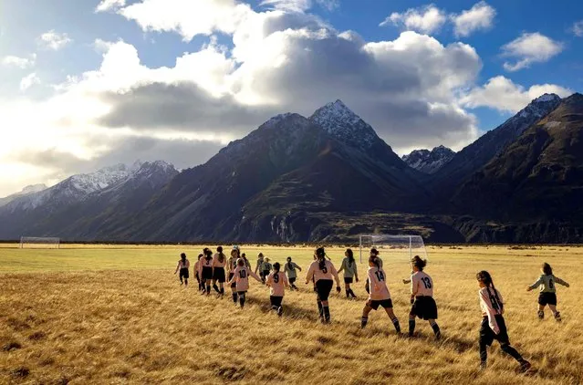 This handout photograph taken by Brett Phibbs on 20 June 2023, and released by Tourism New Zealand shows Tourism New Zealand celebrating one month to go until the FIFA Womenís World Cup 2023ô by installing a full size football pitch at Aoraki Mount Cook. The pitch hosted an exhibition match between local girls as well as a training session with Football Ferns Katie Bowen and Emma Rolston, dubbed the Beautiful Game, played in one of the most beautiful places on earth – New Zealand. (Photo by Brett Phibbs/Tourism New Zealand via AFP Photo)