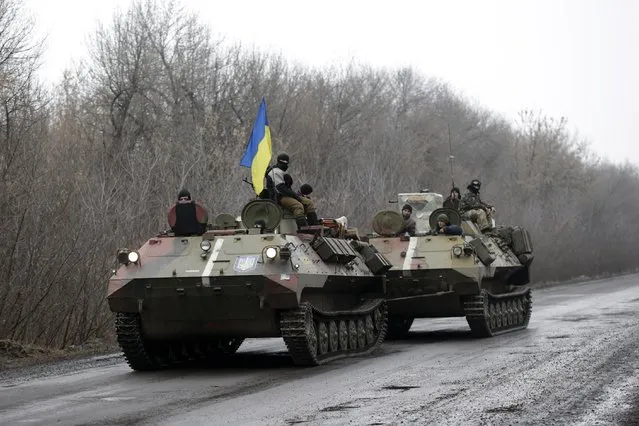 A Ukranian armored vehicle is towed on the road towards the town of Artemivsk, Ukraine, Friday, January 30, 2015. (Photo by Petr David Josek/AP Photo)
