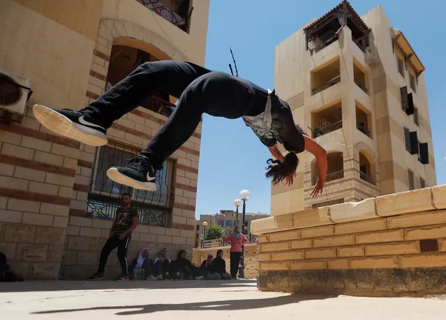 Mariam Emad from Parkour Egypt “PKE” practices her parkour skills around buildings on the outskirts of Cairo, Egypt on July 20, 2018. A group of Egyptian women gather at an abandoned park in a Cairo suburb once a week, climbing walls and jumping around in the strenuous physical discipline known as Parkour, while also challenging the country's conservative social norms. (Photo by Amr Abdallah Dalsh/Reuters)