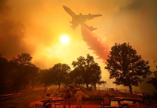 A 747 Global Airtanker makes a drop in front of advancing flames from a wildfire Thursday, August 2, 2018, in Lakeport, Calif. (Photo by Kent Porter/The Press Democrat via AP Photo)