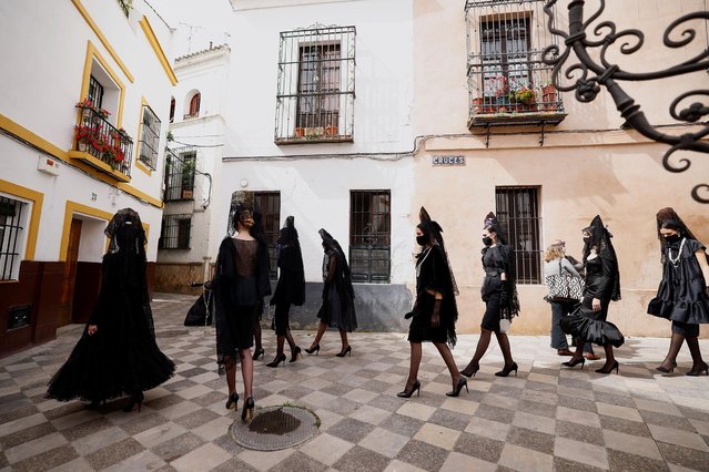 Models wearing mantilla dresses walk during an event to show-off traditional mantilla costumes created by different designers, amid restrictions due to the coronavirus disease (COVID-19) pandemic, in Seville, Spain on March 26, 2021. (Photo by Marcelo del Pozo/Reuters)