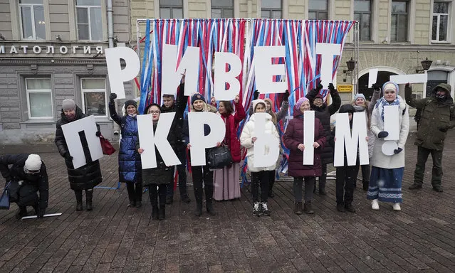 Members of pro-Kremlin organisations hold letters reading “Hello Crimea” during celebration of the anniversary of Crimea annexation from Ukraine in 2014, in St. Petersburg, Russia, Thursday, March 18, 2021. Residents of cities in Crimea and Russia are holding gatherings to commemorate the seventh anniversary of Russia's annexation of the Black Sea peninsula from Ukraine. (Photo by Dmitri Lovetsky/AP Photo)
