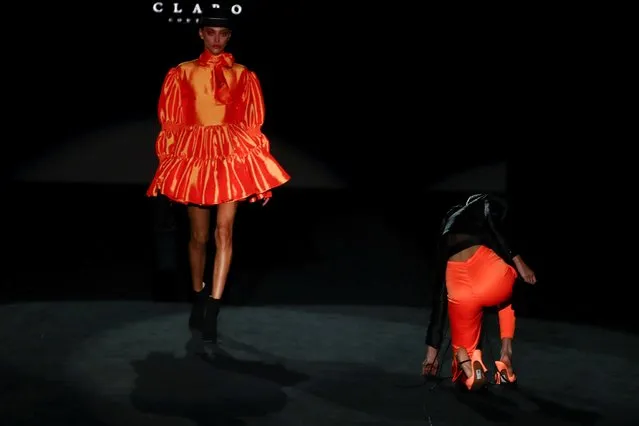 A model falls on the stage as she displays an outfit created by Fernando Claro during the Mercedes Benz Fashion Week, amid the coronavirus disease (COVID-19) outbreak, in Madrid, Spain, April 8, 2021. (Photo by Sergio Perez/Reuters)