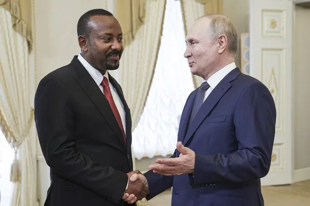 Russian President Vladimir Putin, right, and Ethiopian Prime Minister Abiy Ahmed shake hands during their meeting on the eve of the Russia Africa Summit in St. Petersburg, Russia, Wednesday, July 26, 2023. (Photo by TASS News Agency Host Pool Photo via AP Photo)