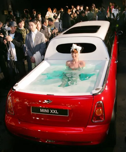 A model wearing a bikini soaks in a jacuzzi on the rear end of a limousine named “Mini XXL” at the Japanese designers' brand THEATRE PRODUCTS Fall Winter 2005 collection, at the National stadium in Tokyo April 6, 2005. The six metre (about 20 feet) long stretch Mini Cooper S, equipped with six wheels, four doors, six passenger seats and a jacuzzi, is touring around Europe and parts of Asia where it is set to be the star attraction at various events, the organizers said. (Photo by Issei Kato/Reuters)