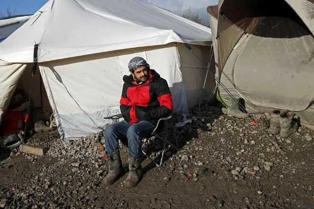 Justyar, 25 years-old, a migrant from Irak sits in front of his tent as he poses in a muddy field called the Grande-Synthe jungle, near Dunkirk, northern France, January 12, 2016. (Photo by Benoit Tessier/Reuters)