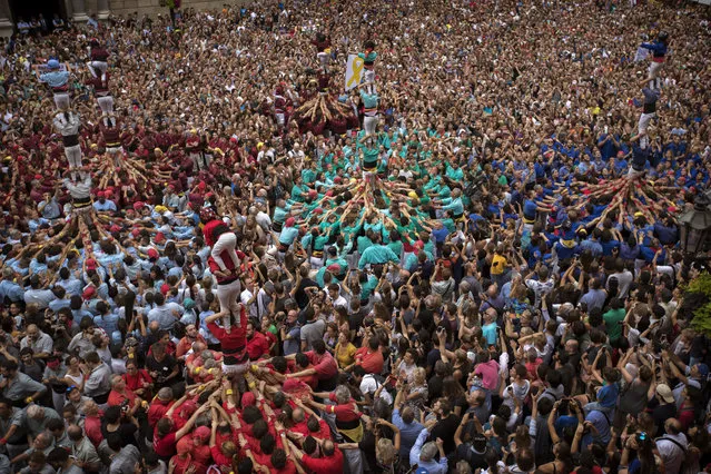 Participants make human towers or “Castellers” during the Saint Merce celebrations in San Jaime square in Barcelona, Spain, Monday, September 24, 2018. The tradition of building human towers or “castells” dates back to the 18th century and takes place during festivals in Catalonia, where “colles” or teams compete to build the tallest and most complicated towers. (Photo by Emilio Morenatti/AP Photo)