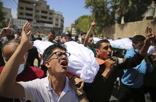 Mourners carry the the bodies of Palestinians who were killed in overnight Israeli airstrikes that hit their homes, during their funeral in Gaza City, Sunday, May 16, 2021. (Photo by Abdel Kareem Hana/AP Photo)