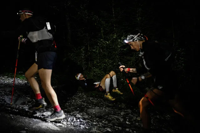 An athlete sleeps on the side of the path during the 20th edition of The Ultra Trail du Mont Blanc (UTMB), a 173km trail race crossing France, Italy and Switzerland in Chamonix, south-eastern France on September 1, 2023. (Photo by Jeff Pachoud/AFP Photo)
